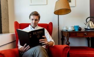 Photo of Florian Gassner reading a book in his office