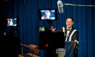 A picture of Santa Ono being filmed for graduation