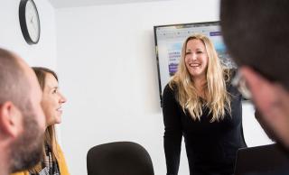 Photo of Taryn Cigagna speaking with colleagues