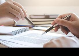 Two hands using pens